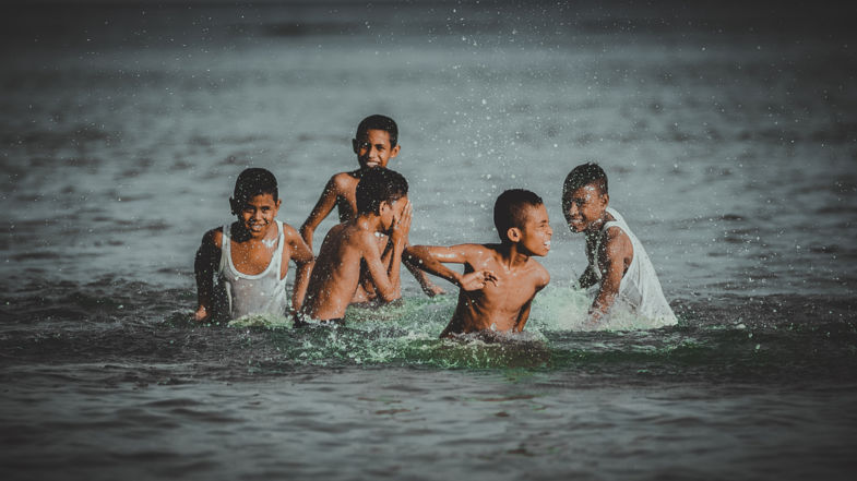 Kinderen in zee bij strand Natsepa, Suli Ambon