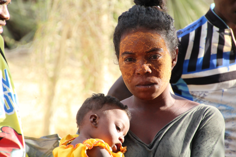 moeder met kind op strand Madagaskar (lege blik in ogen)