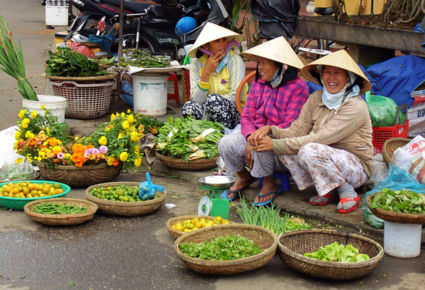 Vrolijke vietnameze vrouwen op de lokale markt in Hoi An