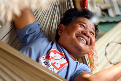 Father of a poor family in his hammock. Extremely happy with what he does have.